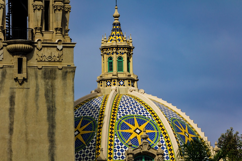 VIEW OF BALBOA PARK DOME WITH THE TOWER TO THE LEFT SLIGHTLY BLURRED. DETAIL ON DOME TILE PATTERNS WITH BLUE SKY