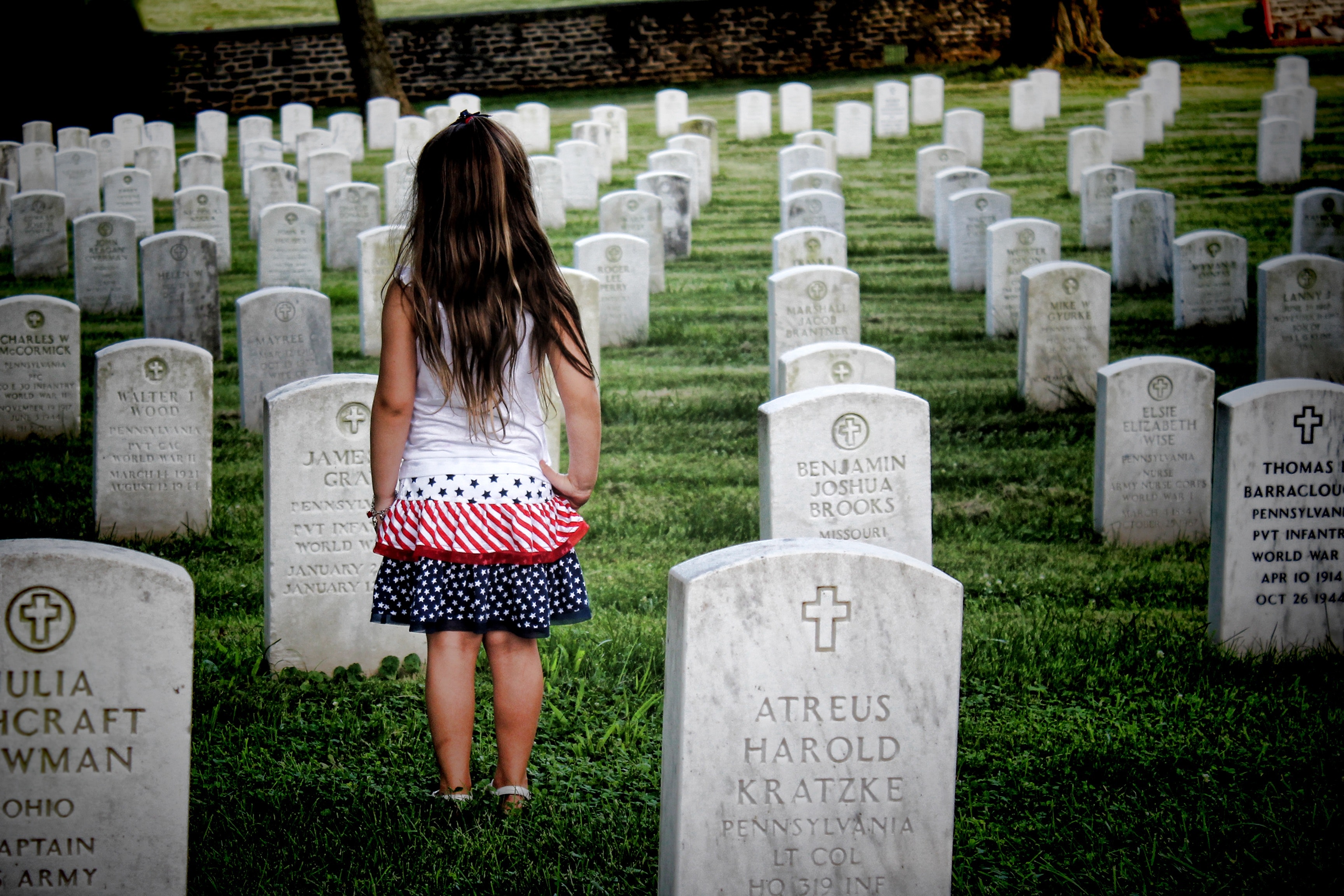 little girl in cemetery honoring fallen soldiers